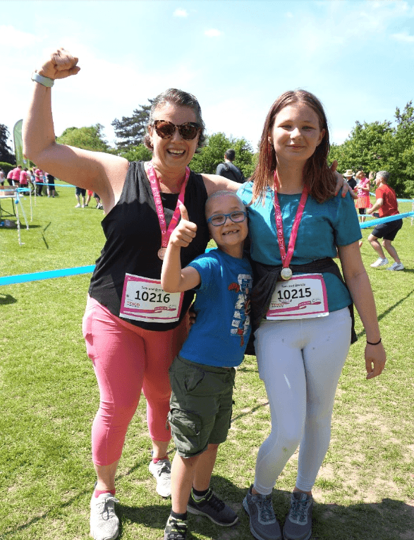 Jasper with his Mum and sister, celebrating after taking part in a Pretty Muddy Kids event on a sunny day.