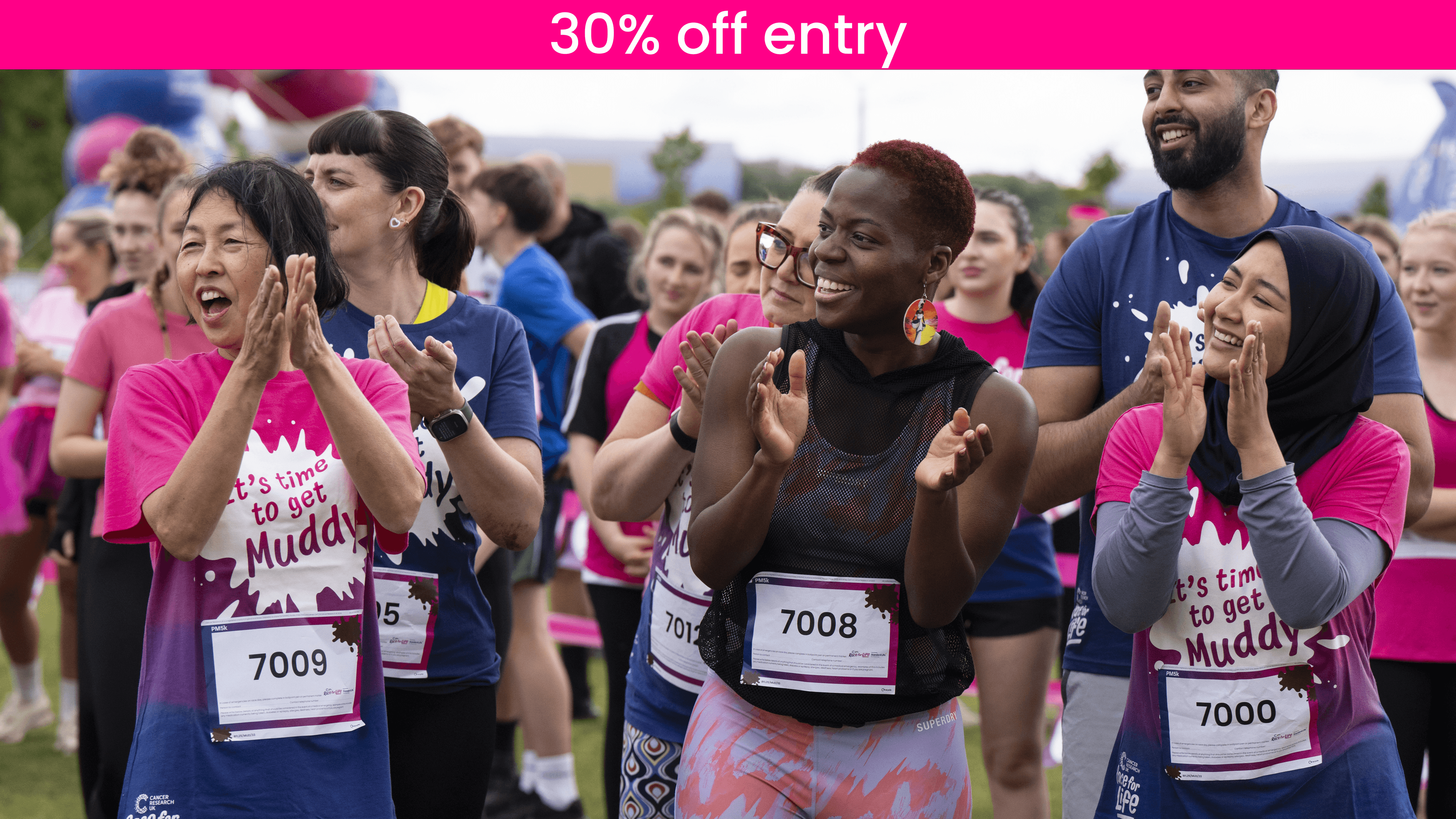 A group of participants cheering and clapping in the crowd at Race for Life.