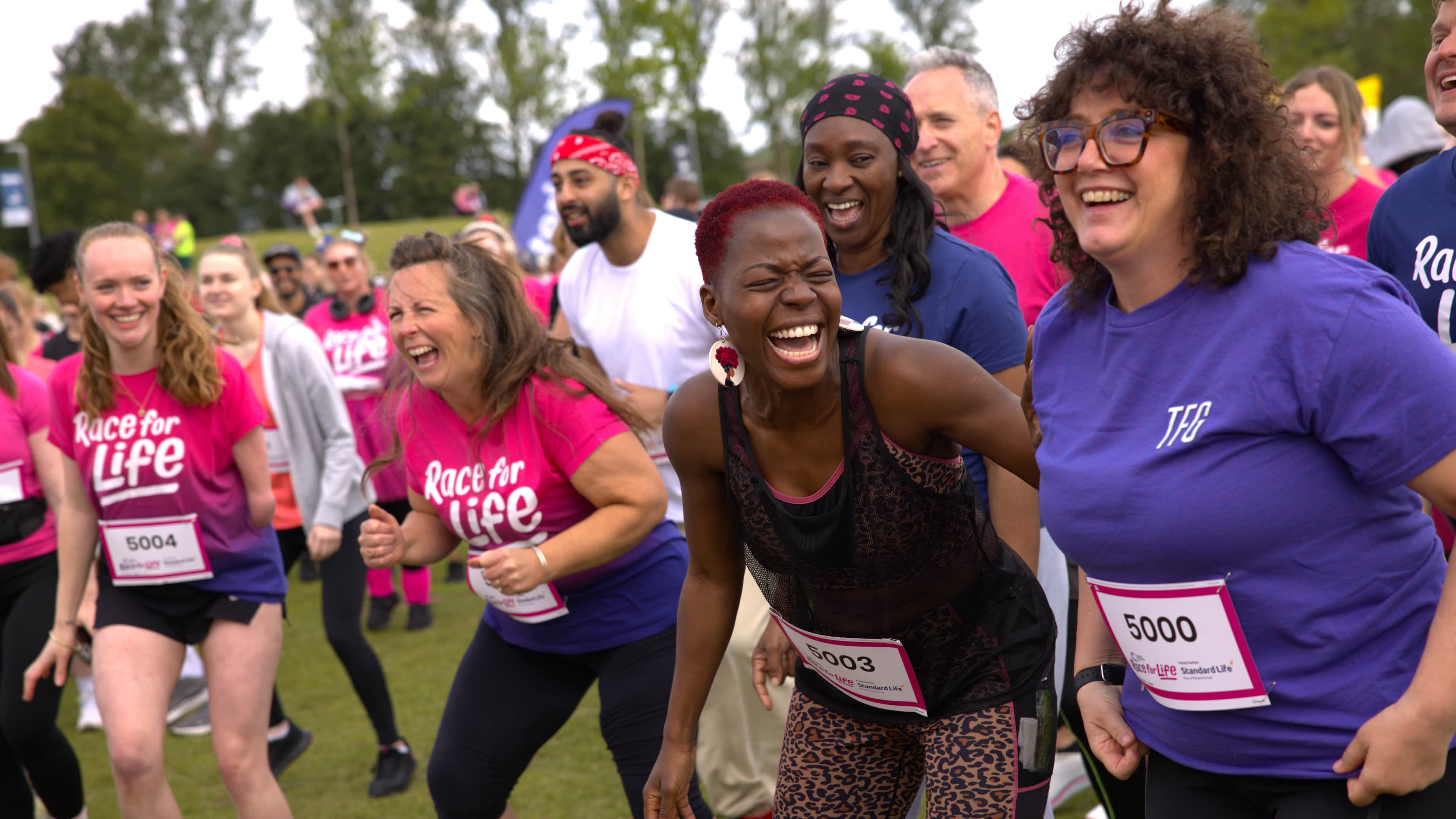 a group warming up pre race smiling and laughing with eachother.