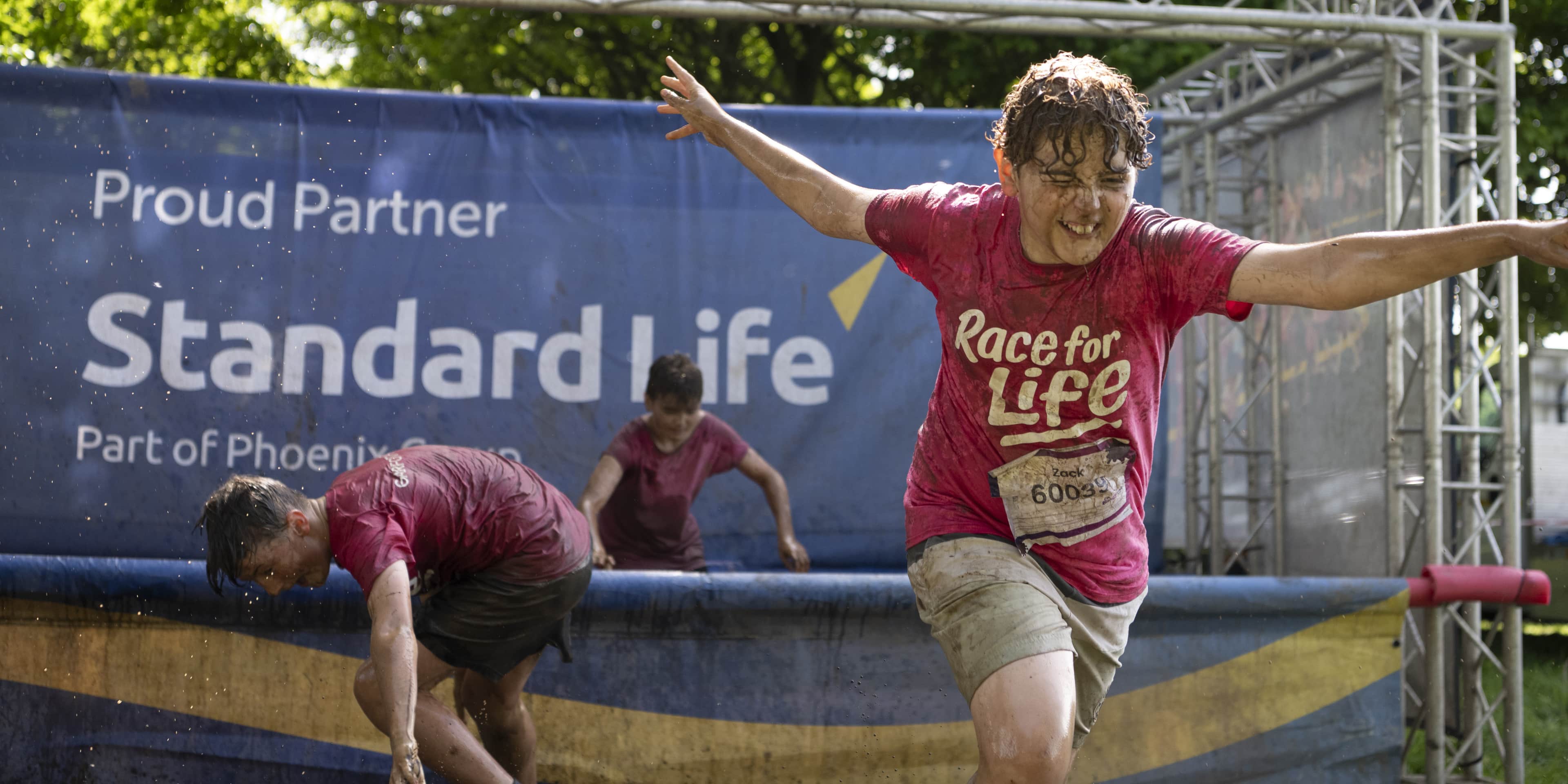 A mud child makes their way though one of Standard Life's sponsored obstacles.