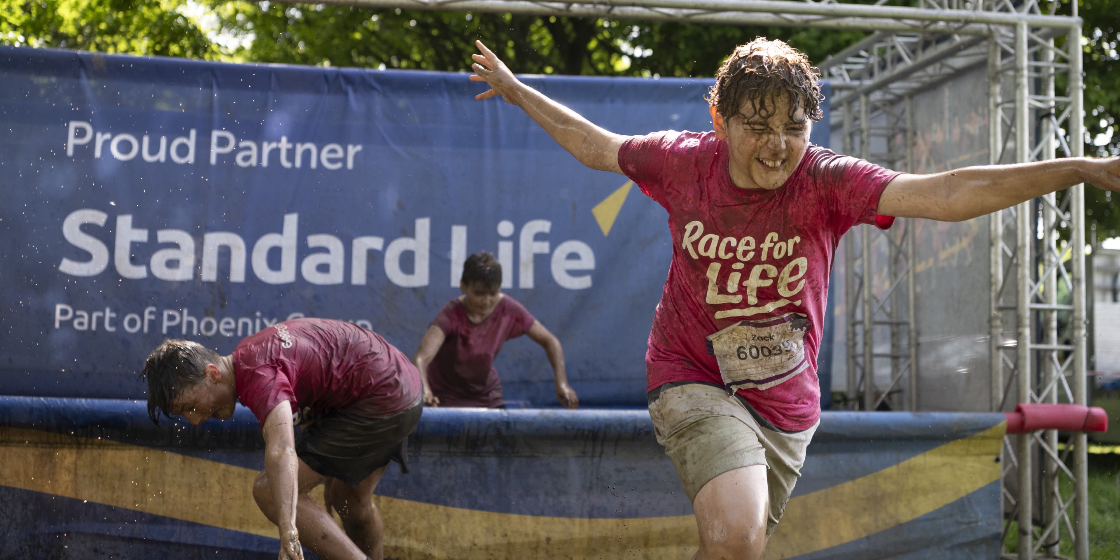 A mud child makes their way though one of Standard Life's sponsored obstacles.