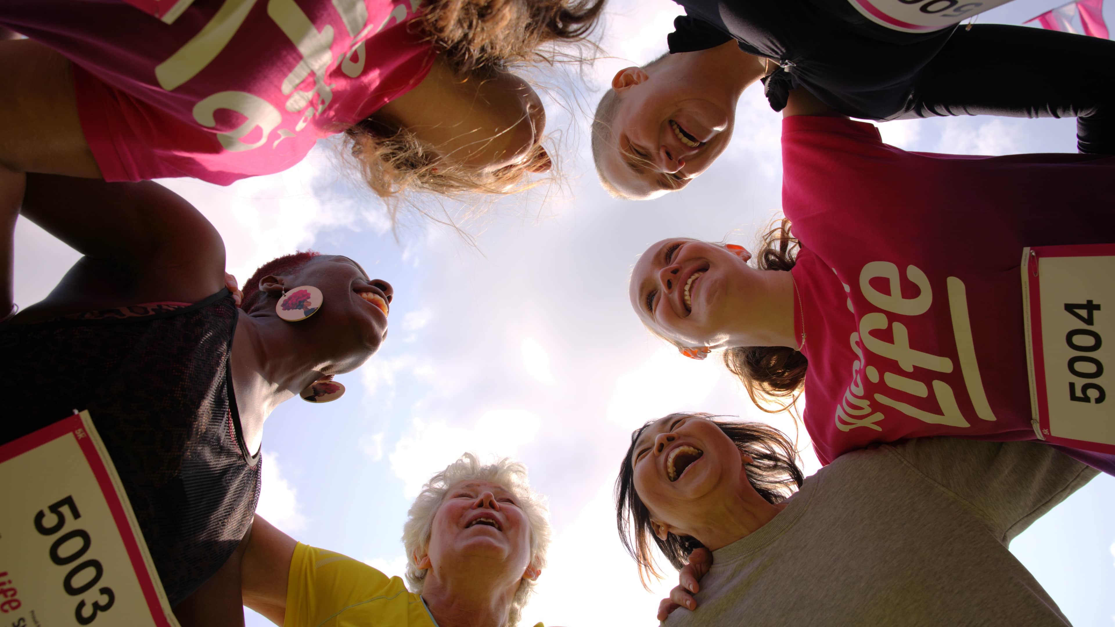 Group of participants all smiling in a huddle.