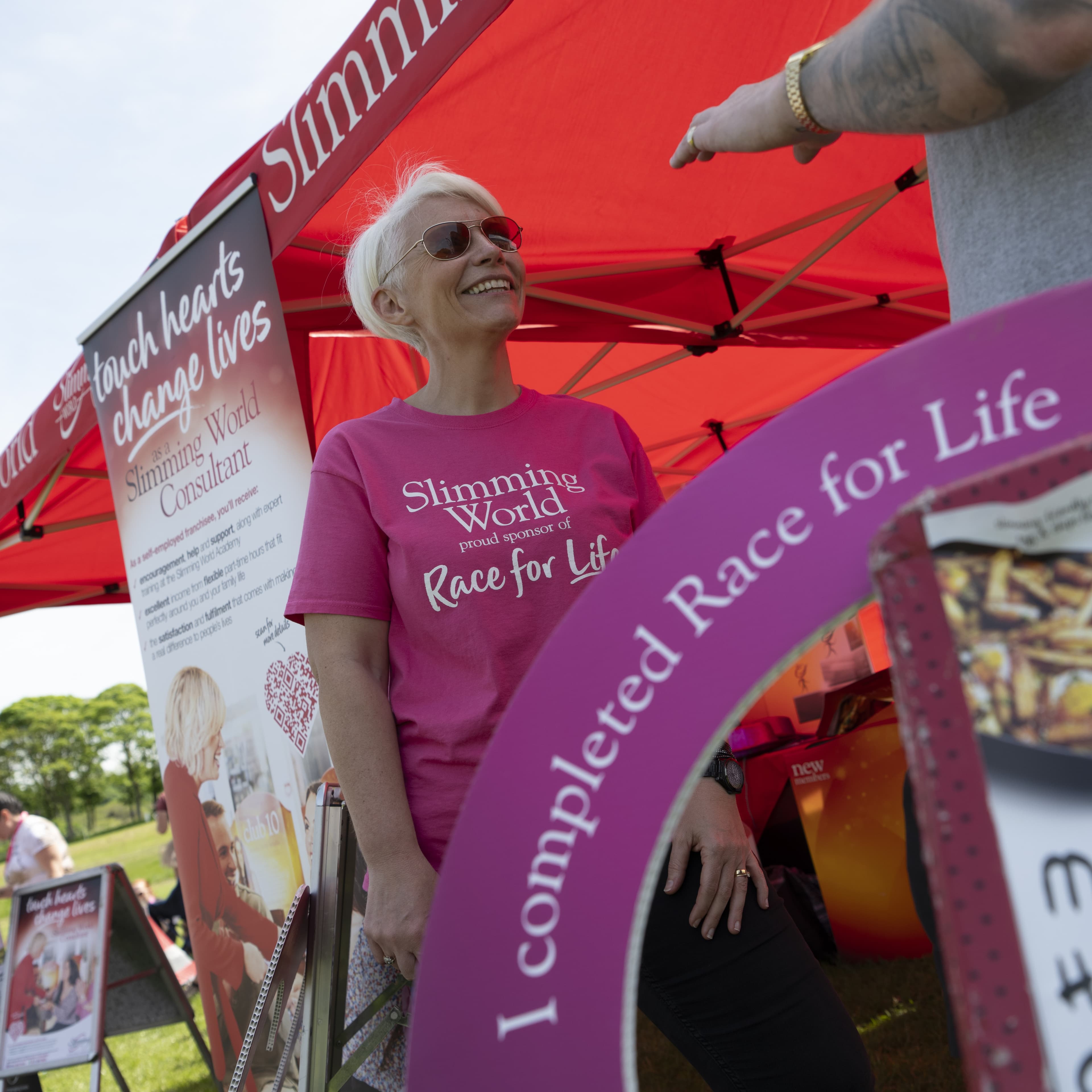 A Slimming World rep in a pink tshirt at the Slimming World tent at RFL.