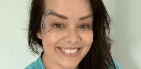 Philippa, an Event Volunteer, is smiling with glitter on her face.