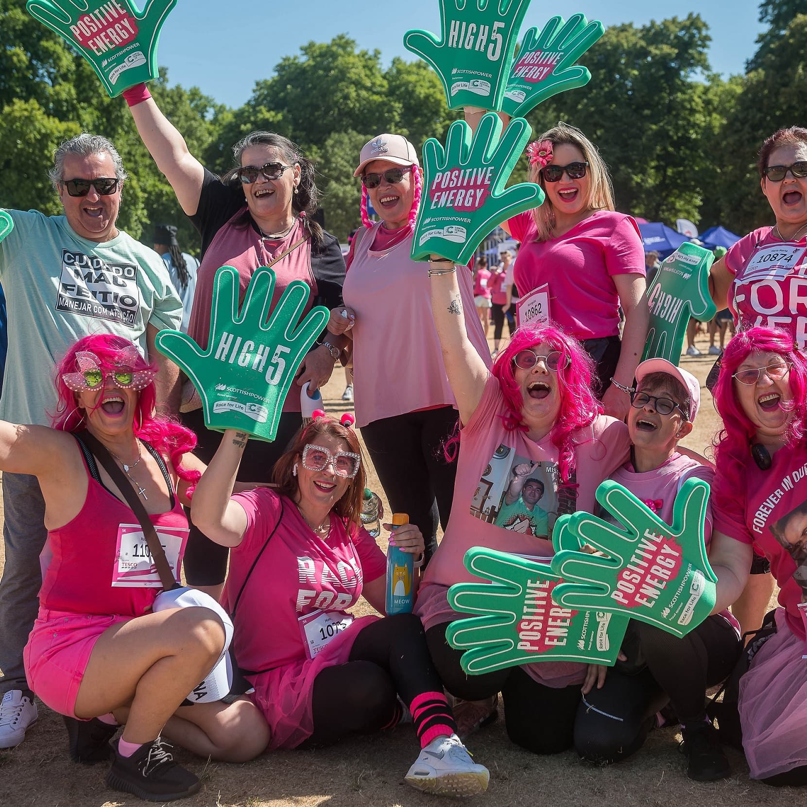 Scottish Power colleagues at a sunny Race for Life, wearing Race pink t-shirts, wigs and sunglasses.