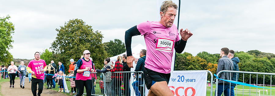 Image of three people taking part in Race for Life, all running mid-race