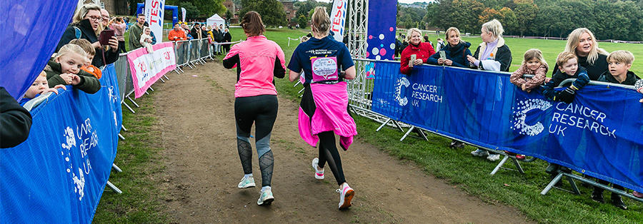 Photo of three people taking part in Race for Life, all running mid-race