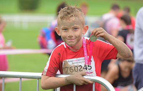Boy with a medal after taking part in Pretty Muddy Kids