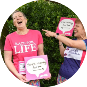 Two women in race for life t-shirts laughing