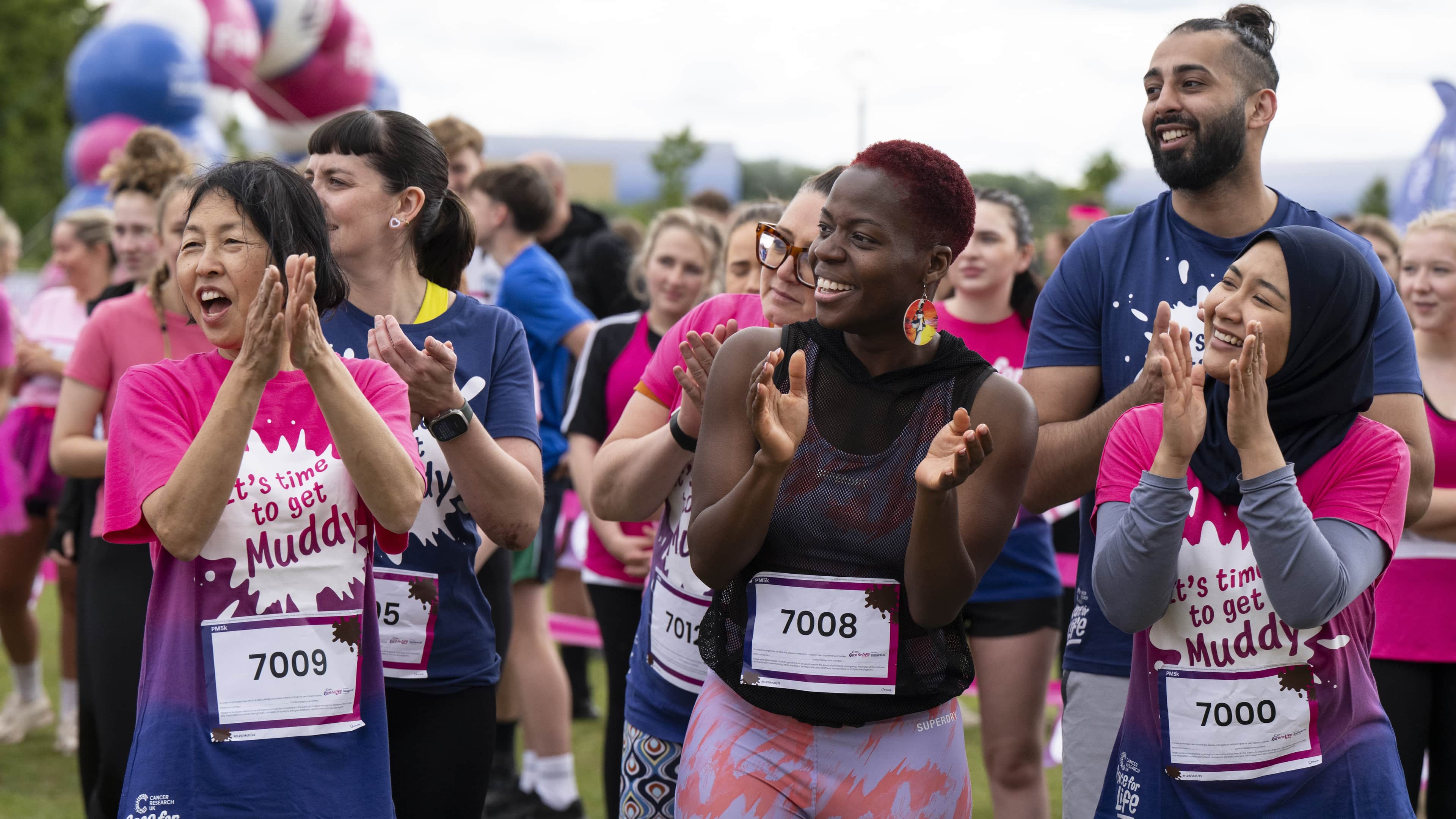 A group of participants cheering and clapping in the crowd at Race for Life.